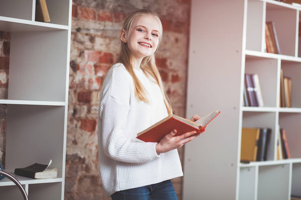 tiener meisje in een bibliotheek - Foto, afbeelding