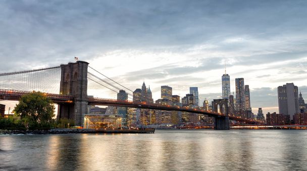 Вид на Манхэттен и Бруклинский мост из парка Бруклинский мост на закате, Нью-Йорк
. - Фото, изображение