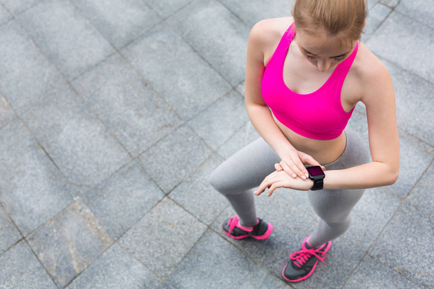 Jonge vrouwelijke jogger met smartwatch - Foto, afbeelding