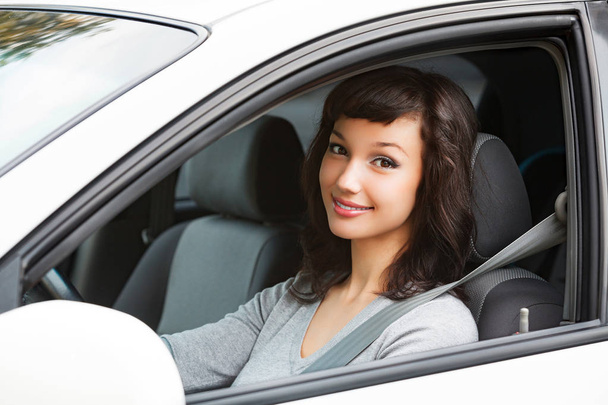 Mujer bonita conductor sonriendo a usted desde el coche blanco
 - Foto, Imagen