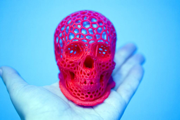 Crânio impresso com plástico de cor vermelha em uma impressora 3d. - Foto, Imagem