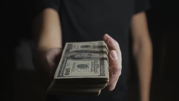 Close-up van een man geven een vat dollarbiljetten. Het concept van de lonen. Liefdadigheid. - Video