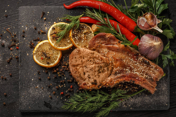 Grilled meat and vegetables on a black rustic background. - Φωτογραφία, εικόνα