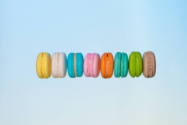 Colorful macarons cakes. Sweet french macaroons flying in motion. - 写真・画像