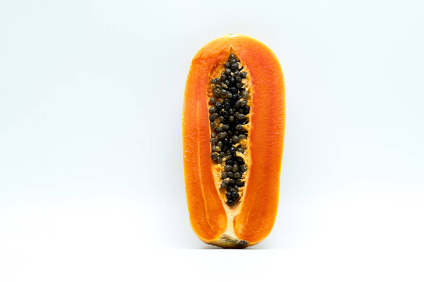 Μισό ώριμο papaya φρούτων με σπόρους που απομονώνονται σε λευκό φόντο με αντίγραφο χώρου. Φυσική πηγή βιταμίνης C, φυλλικού οξέος και ανόργανων στοιχείων. Υγιεινή διατροφή για έγκυος και το στήθος-ταΐζοντας γυναίκα - Φωτογραφία, εικόνα