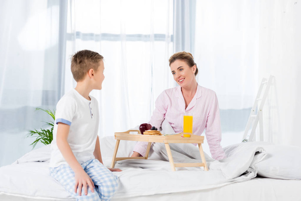 little son giving breakfast in bed for mother - Photo, Image