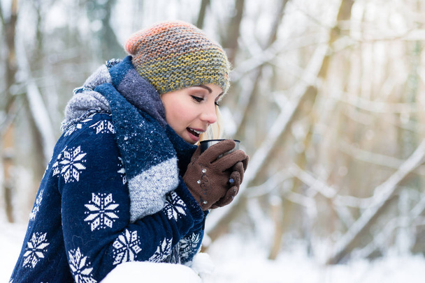 Woman freezing on a cold winter day warming herself up with hot - Photo, image