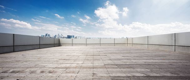 mavi gökyüzünde beton duvarla çevrili boş tuğla zemin - Fotoğraf, Görsel