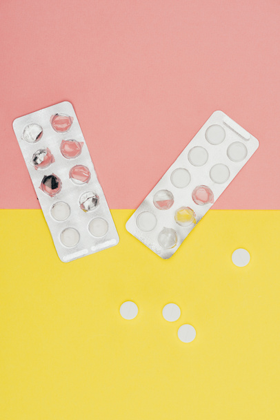 top view of pills isolated on pink and yellow background - Photo, Image