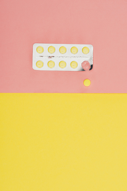 top view of pills isolated on pink and yellow background - Фото, зображення