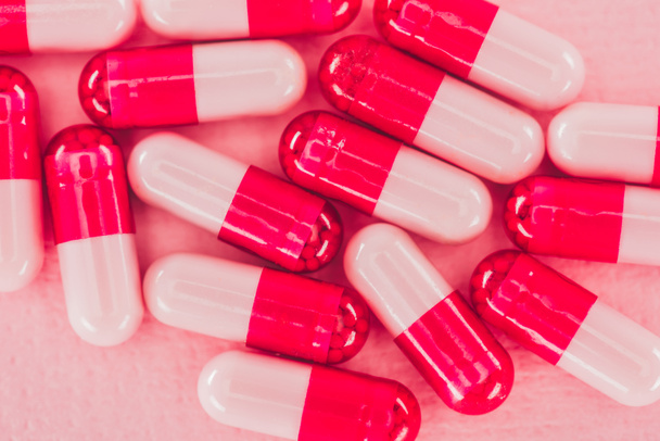 vista de perto de pílulas em pano de fundo rosa
 - Foto, Imagem