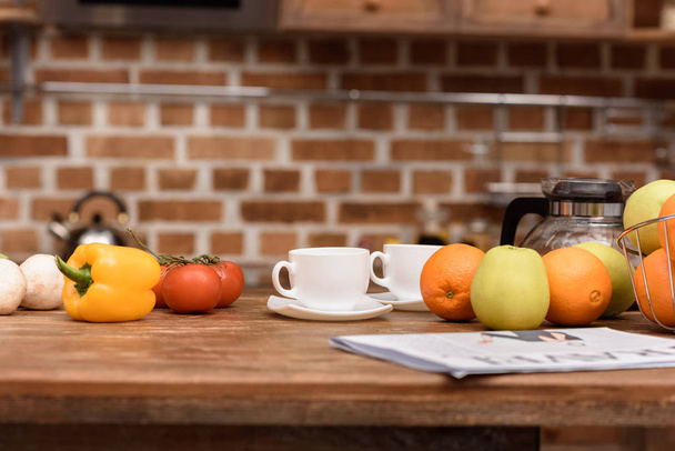 cups with coffee and vegetables with fruits on table - Photo, Image