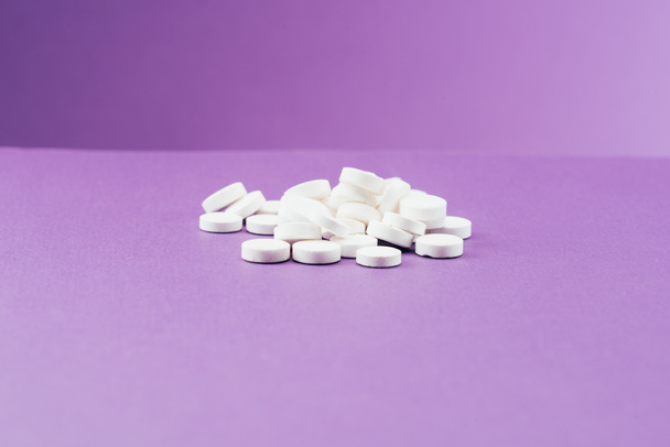 vista da vicino di pillole organizzate su sfondo viola
  - Foto, immagini