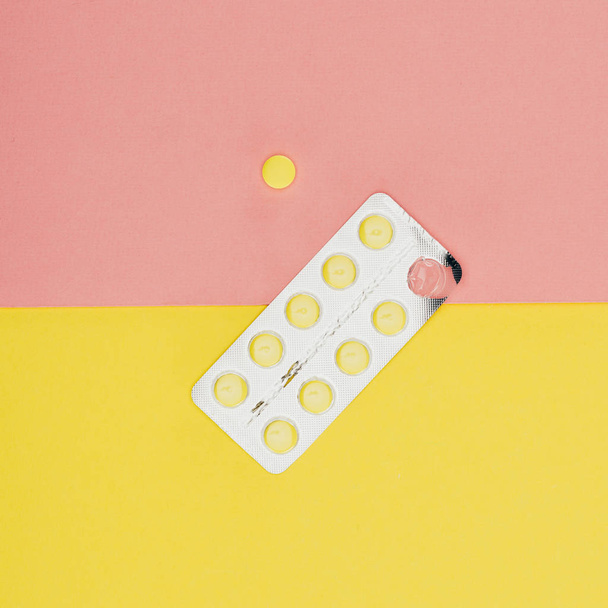 top view of pills isolated on pink and yellow background - Foto, immagini