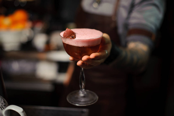 barman holds alcoholic cocktail sour mix cherry - Zdjęcie, obraz