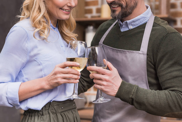 cropped image of husband and wife toasting with glasses of wine  - Foto, Imagem