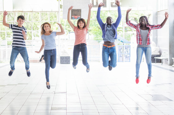 Μικτή φυλή έφηβοι ευτυχισμένη jumping. - Φωτογραφία, εικόνα