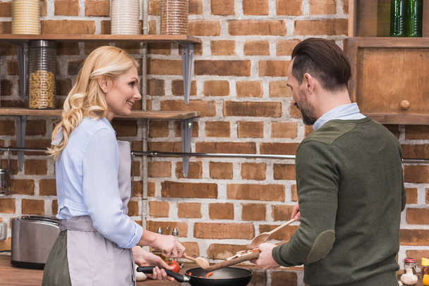 wife and husband cooking together at kitchen - Zdjęcie, obraz