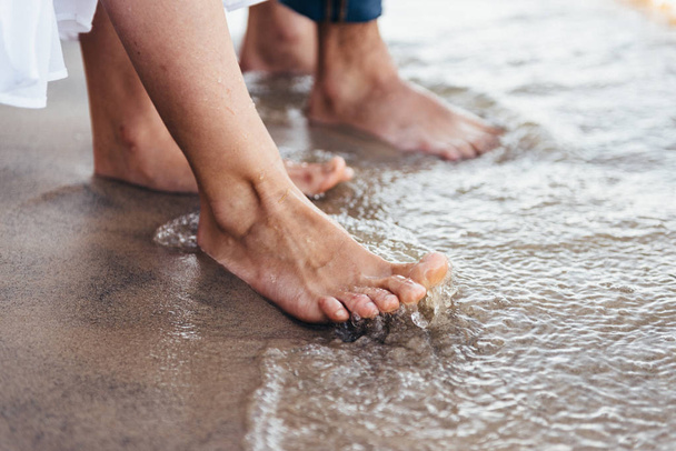 pareja enamorada de pie descalza en la playa mojado arena
 - Foto, imagen