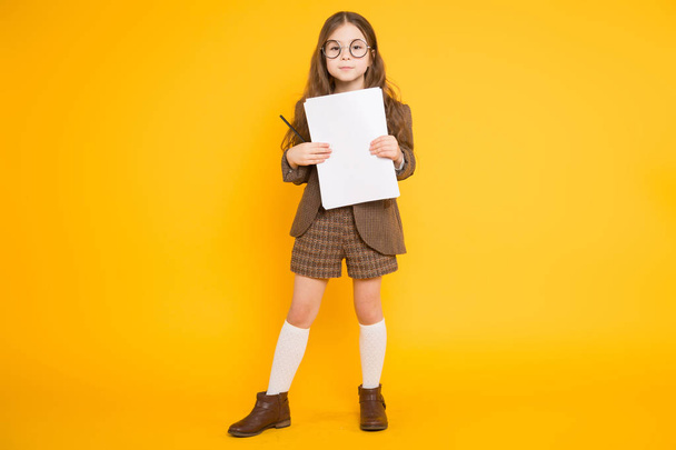 Χαριτωμένο μικρό κορίτσι μελαχρινή κρατώντας κενό έγγραφα και μολύβι - Φωτογραφία, εικόνα