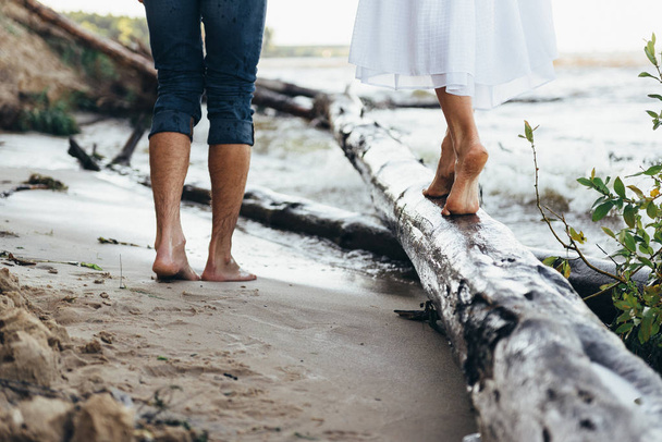 gambe di un ragazzo e una ragazza a piedi lungo la spiaggia, la ragazza è st
 - Foto, immagini