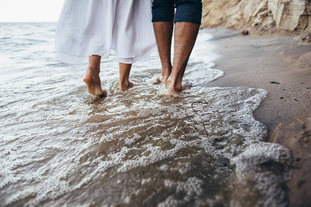 a couple in love walking barefoot on the wet sand on the beach i - Fotoğraf, Görsel