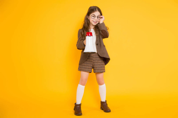 Roztomilá brunetka holčička s megafon na žlutém podkladu  - Fotografie, Obrázek