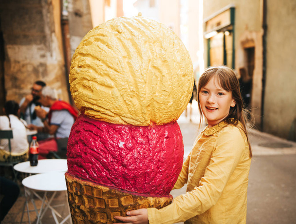Lustiges Porträt eines hübschen kleinen Mädchens mit riesigem Eis - Foto, Bild