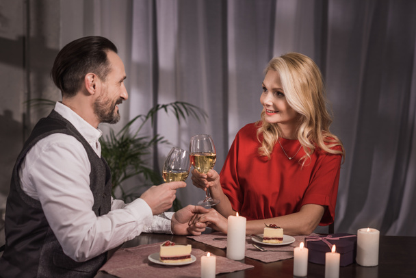 ευτυχισμένο ζευγάρι τσούγκριζαν με ποτήρια κρασί στο σπίτι - Φωτογραφία, εικόνα