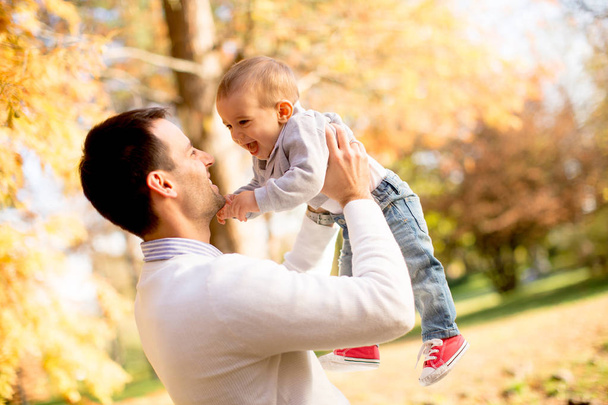 若い父親し、晴れた日で秋の公園で遊んでいる少年を赤ちゃん - 写真・画像