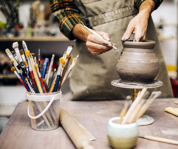 Giovane uomo che fa ceramica in laboratorio
 - Foto, immagini