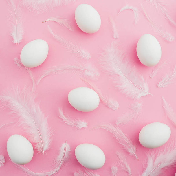 Paskalya yumurtaları ve pembe bir arka plan beyaz tüyler. Düz yatıyordu. Üstten Görünüm - Fotoğraf, Görsel