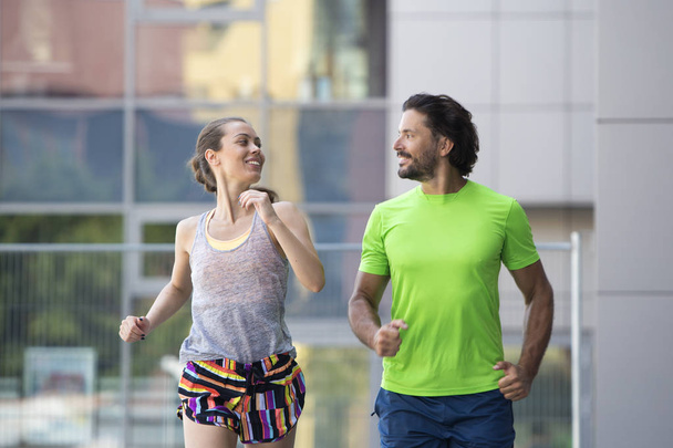 Couple running in urban enviroment  at hot summer day - Photo, Image