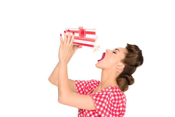 widok boczny stylowe młoda kobieta jedzenie popcorn na białym tle - Zdjęcie, obraz