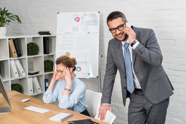 businessman talking by phone while his annoyed colleague trying to work - Photo, Image
