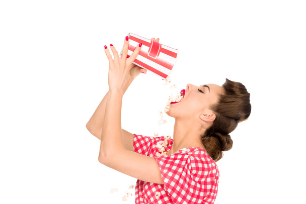 widok boczny stylowe młoda kobieta jedzenie popcorn na białym tle - Zdjęcie, obraz