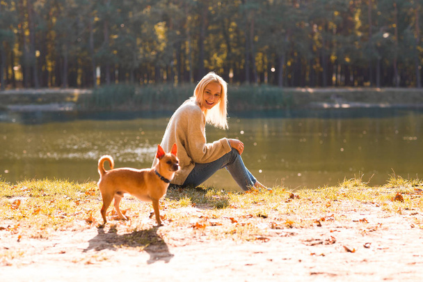 girl in an autumn park near a lake holds a tablet - Photo, image