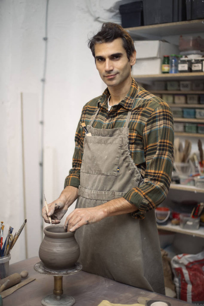 Jonge man maken van aardewerk in werkplaats - Foto, afbeelding