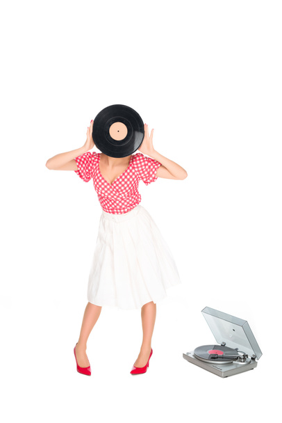 obscured view of woman in pin up style clothing covering face with vinyl record isolated on white - Photo, Image