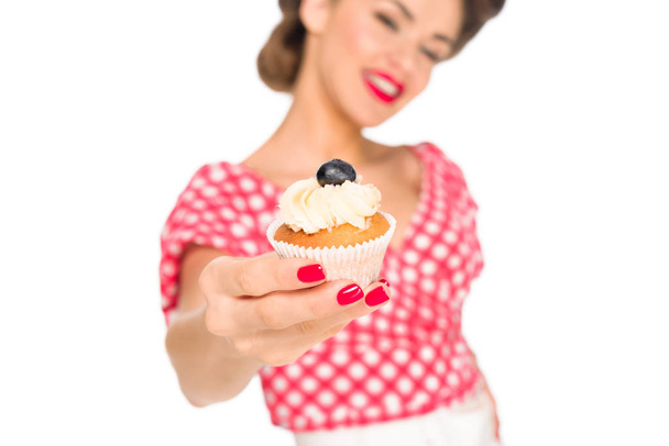 selective focus of woman in pin up clothing showing cupcake isolated on white - Valokuva, kuva