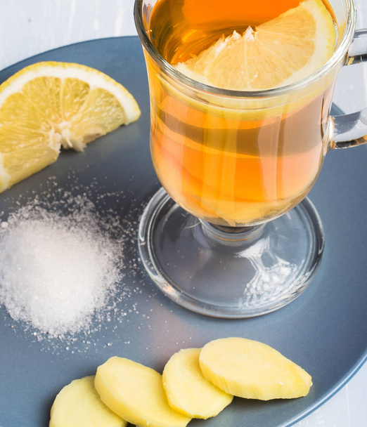 A cup of ginger tea with lemon on a wooden background. - Photo, Image