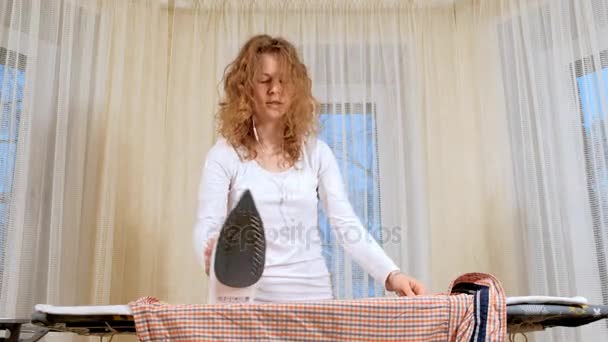 Funny and beautiful woman ironing clothes and dancing at home - Footage, Video