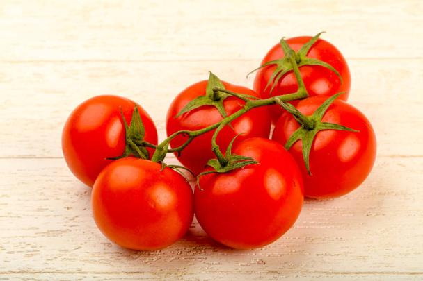 frischer saftiger Tomatenzweig über dem hölzernen Hintergrund - Foto, Bild