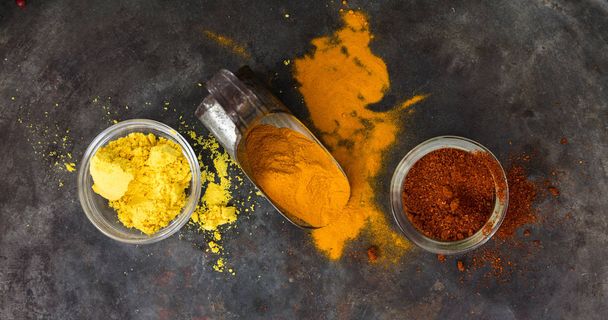 Colorful spices and an old metal scoop on metal rusty background, top view - Foto, immagini