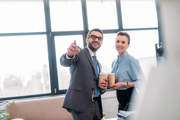 businesspeople having coffee to go at office and pointing somewhere - Photo, Image