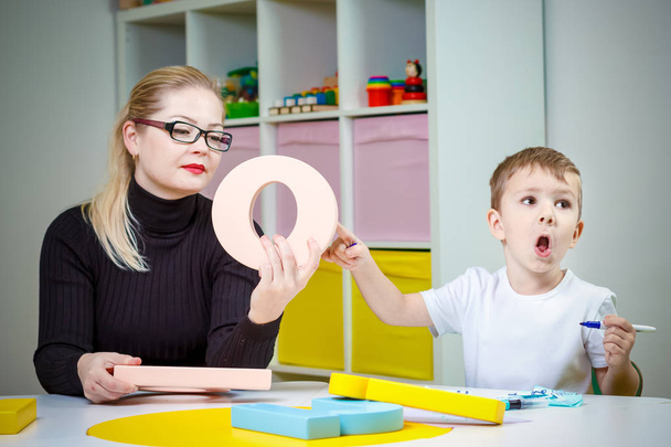boy and his mother, a babysitter, or speech therapist learning letters - Foto, imagen