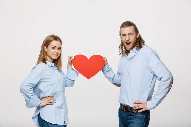 Retrato de pareja feliz joven enamorada sosteniendo el corazón de papel rojo
. - Foto, imagen