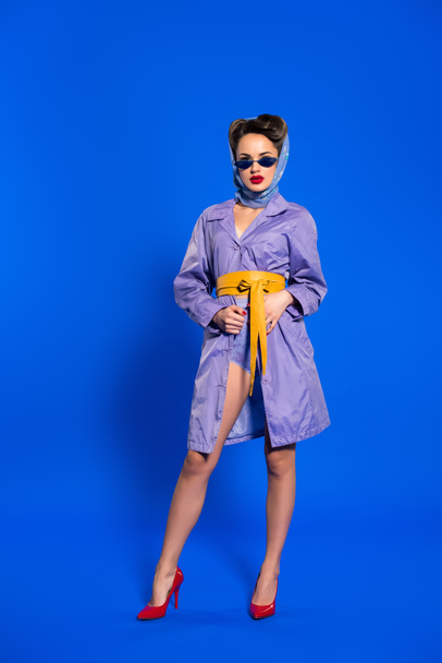 stylish woman in retro clothing and sunglasses isolated on blue - Photo, Image