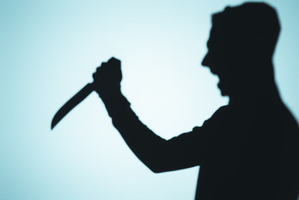 σκιά της πρόσωπο φωνάζοντας και κρατώντας το μαχαίρι σε μπλε - Φωτογραφία, εικόνα