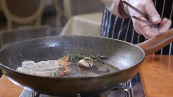 Primo piano di uno chef Preparazione Flambe Style Dish on a Pan. Al rallentatore. Olio e alcool Accendere con fiamme aperte. Cucinare gamberetti tigre. Girato in 4k
 - Filmati, video
